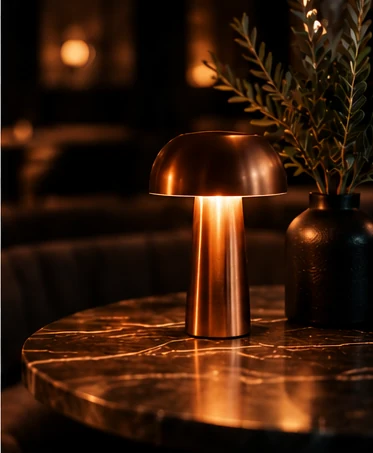 Warm copper table lamp next to olive branches